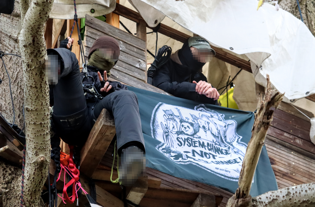 Zwei Menschen mit Fahne im Baumhaus